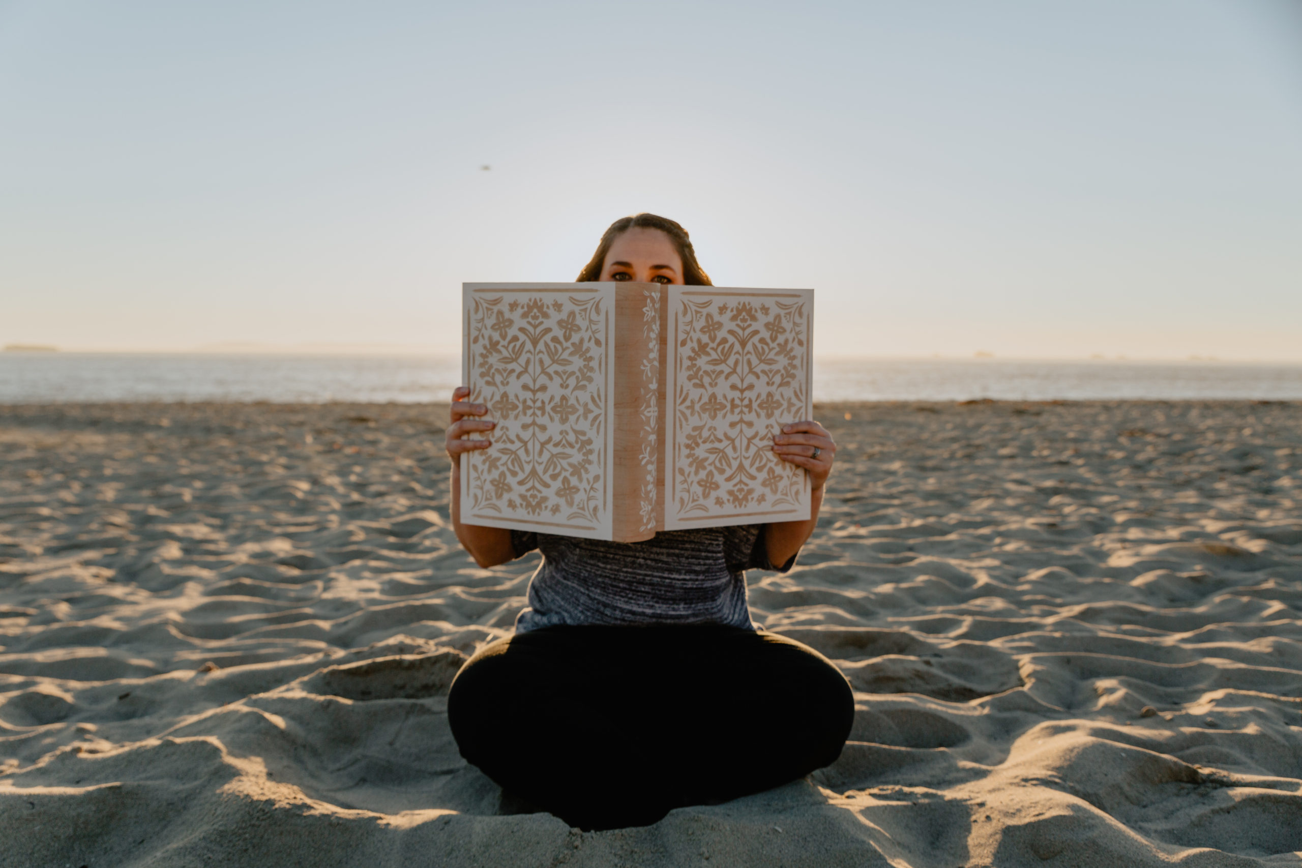 Author Photo with book on the beach